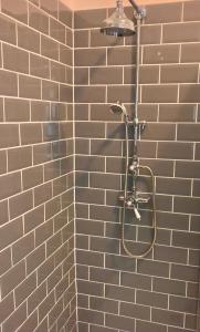 a shower in a bathroom with a brick wall at Hayes Suite in Oswestry