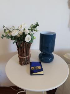 a table with a vase of flowers and a book at Blue Apartment in Pescara