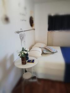 a small bed with a table with a plant on it at Blue Apartment in Pescara