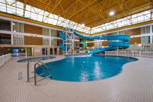 einem großen Pool mit Rutsche in einem Gebäude in der Unterkunft Superior Inn Hotel and Conference Centre Thunder Bay in Thunder Bay