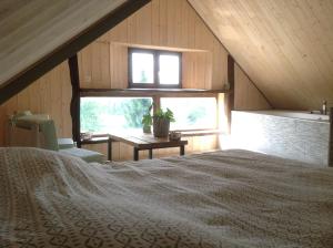 a bedroom with a bed and a sink in a attic at LES ROCAILLES in La Forêt-Auvray