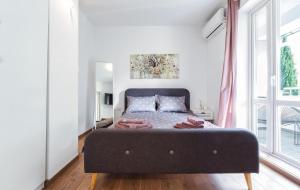a bedroom with a bed with a large window at Studio Central - 50 meters from Sea in Poreč