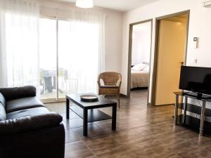 a living room with a couch and a table and a television at Residence Farenc vue sur la lagune in Marseillan