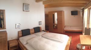 a bedroom with a large bed with white sheets at Hotel Alpenland in Niederau