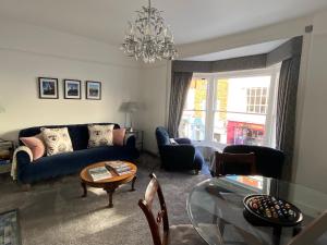 a living room with a blue couch and a glass table at Purlins Holiday Apartment in Salisbury