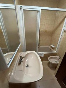 uma casa de banho com um lavatório, uma banheira e um WC. em Hostal Restaurante Luz de Luna em Vilanova de Arousa