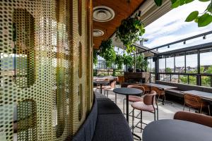 a restaurant with tables and chairs and windows at Hotel Rum Budapest in Budapest