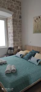 um quarto com uma cama grande com duas almofadas em Simply Dubrovnik em Dubrovnik