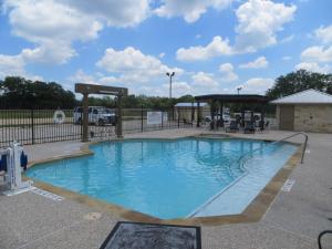 a large swimming pool in a parking lot at Hotel Texas Hallettsville in Hallettsville