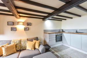 a living room with a couch and a kitchen at Chatterbox Cottage in Wirksworth