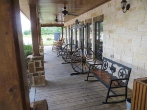a porch with benches and tables on a building at Hotel Texas Hallettsville in Hallettsville