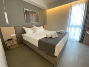a bedroom with a bed with two towels on it at Sicilia's Art Hotel & Spa in Acitrezza