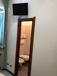 łazienka z toaletą i telewizorem na ścianie w obiekcie Hotel Amico Fritz w mieście Livorno +16 zdjęć