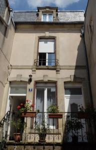 ein Gebäude mit einem Balkon mit Pflanzen in der Unterkunft Résidence Thalassum in Bourbonne-les-Bains