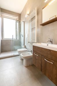 a bathroom with a toilet and a sink and a shower at Leone Guest House in Follonica