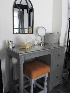 a dressing table with a mirror and a stool at Purlins Holiday Apartment in Salisbury
