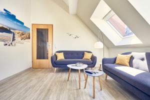 sala de estar con sofá azul y mesa en Haus Pamir _ Fewo 28 en Cuxhaven