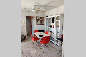 comedor con mesa y sillas rojas en Appartement Golf Saint Thomas - Belle résidence en Béziers