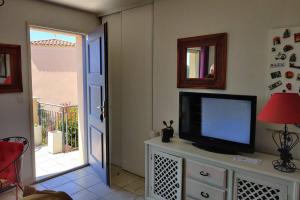 una sala de estar con TV en un tocador en Appartement Golf Saint Thomas - Belle résidence, en Béziers