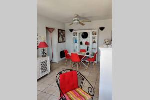 uma sala de jantar com cadeiras vermelhas e uma mesa em Appartement Golf Saint Thomas - Belle résidence em Béziers