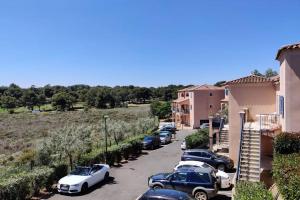 uma fila de carros estacionados num parque de estacionamento em Appartement Golf Saint Thomas - Belle résidence em Béziers