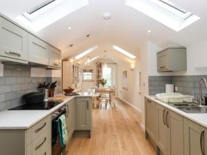 a large kitchen with white cabinets and a dining room at Norton in Keswick