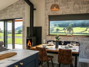 a dining room with a table and a fireplace at Meadow View in Meifod