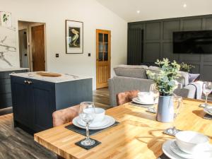 a dining room and living room with a table and chairs at Meadow View in Meifod