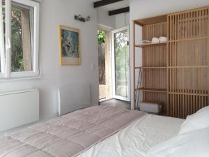 Un dormitorio con una cama grande y una ventana en Chambre indépendante avec terrasse privée et piscine en Nimes