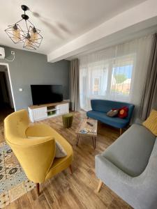 a living room with a blue couch and a tv at Dominic Apartment Unirii Square in Timişoara