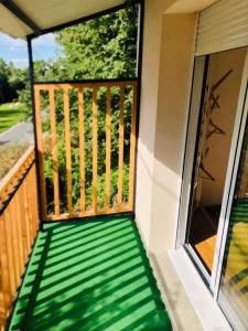 a balcony with green flooring on a house at Logis Hôtel Les TILLEULS in Bruère-Allichamps