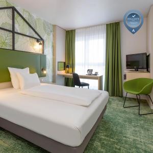 ein Hotelzimmer mit einem großen Bett und einem Schreibtisch in der Unterkunft Mercure Hotel Hannover Mitte in Hannover