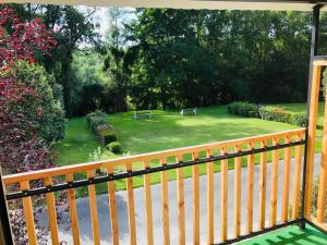 een veranda met uitzicht op een tuin met banken bij Logis Hôtel Les TILLEULS in Bruère-Allichamps