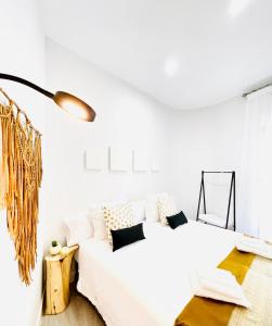 a white bedroom with a bed and a table at Alojamiento Hermanos Garnelo in Montilla +18 photos