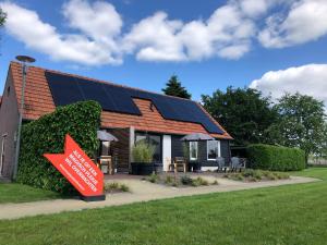 une maison avec des panneaux solaires sur le toit dans l'établissement Bed & Breakfast Bed in Brabant Veghel, à Veghel