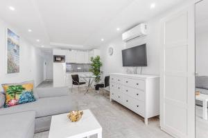 a living room with a couch and a tv at Tenerife Royal Gardens One Bedroom Apartment in Playa de las Americas
