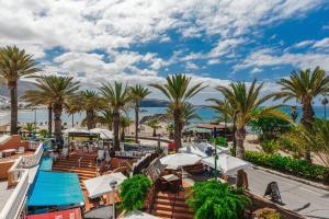 a view of the beach and palm trees at Tenerife Royal Gardens One Bedroom Apartment in Playa de las Americas