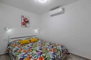 a bedroom with a bed with a colorful comforter at Tenerife Royal Gardens One Bedroom Apartment in Playa de las Americas