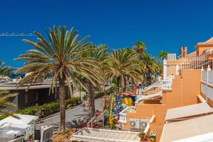 a view of a street with palm trees at Tenerife Royal Gardens One Bedroom Apartment in Playa de las Americas