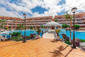 a resort with a swimming pool and a large building at Tenerife Royal Gardens One Bedroom Apartment in Playa de las Americas