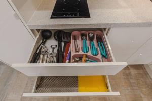 a drawer filled with cooking utensils under a counter at Tenerife Royal Gardens One Bedroom Apartment in Playa de las Americas