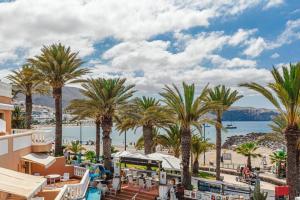 a view of a beach with palm trees and a train at Tenerife Royal Gardens One Bedroom Apartment in Playa de las Americas