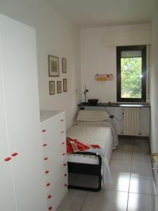 ein Schlafzimmer mit einem Bett, einer Kommode und einem Fenster in der Unterkunft Appartamento Sirolo in Sirolo