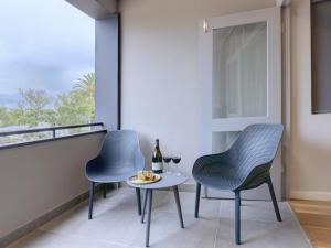 a balcony with two chairs and a table with wine glasses at Harvil House in George