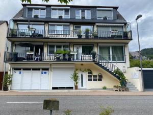 a large house with white doors and a balcony at Appartements Moselblick in Klotten