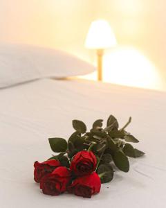 a bouquet of red roses sitting on a bed at Casa Igarassu in Igarassu