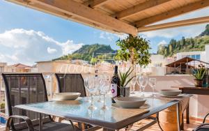 a table with wine glasses and a bottle on a balcony at Ven Luxury Apartment in Zakynthos
