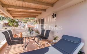 a dining room with a table and chairs on a balcony at Ven Luxury Apartment in Zakynthos