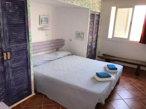 a bedroom with a bed with two towels on it at ED REXII ático in Es Pujols