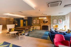 ein Wohnzimmer mit einem blauen Sofa und einem Kamin in der Unterkunft Holiday Inn Cambridge, an IHG Hotel in Cambridge